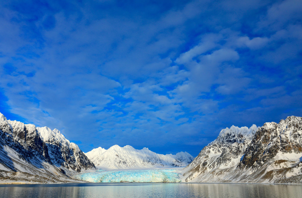 Schneebedeckte Berge und blauer Gletscher auf Svalbard, Norwegen